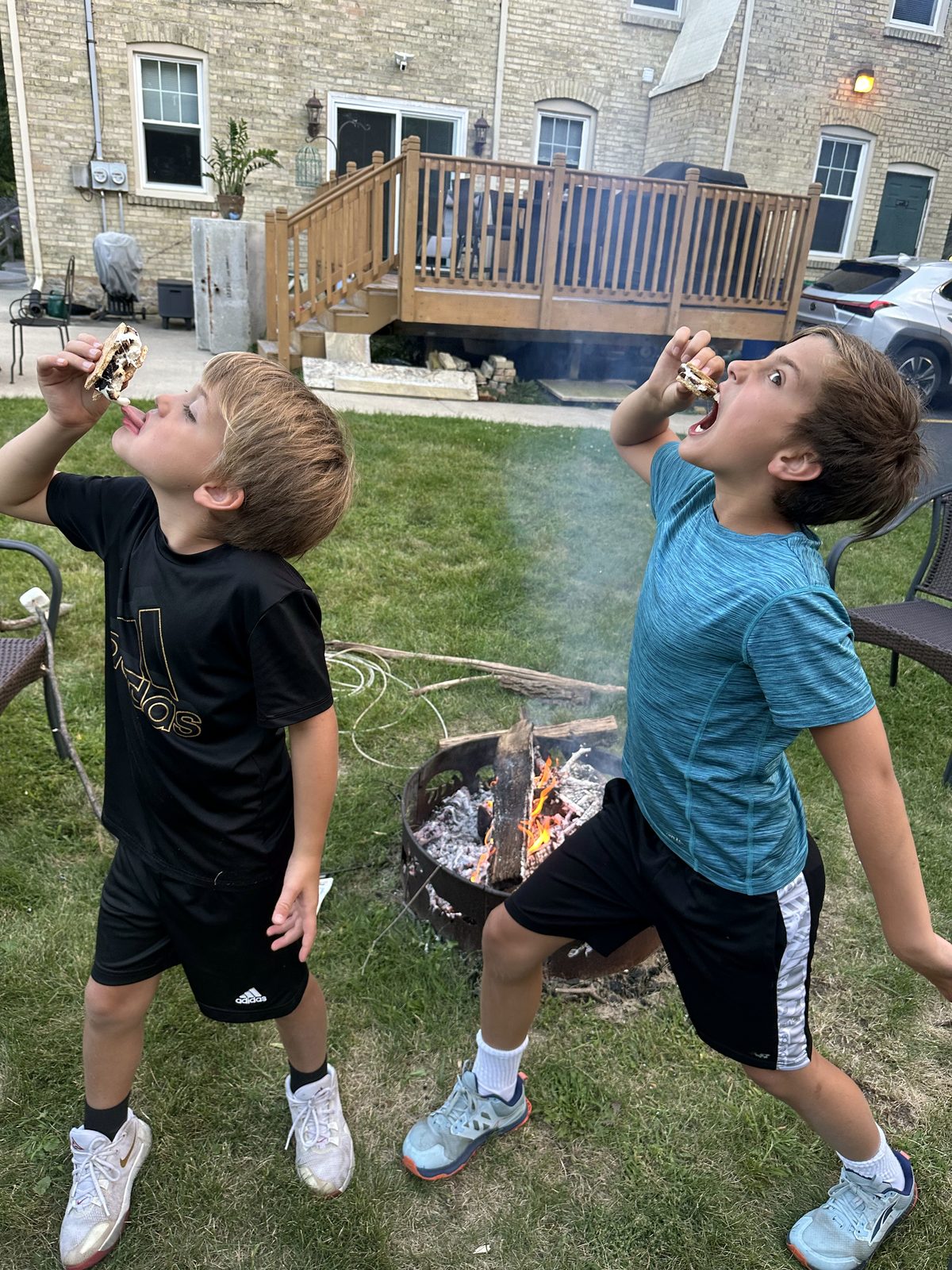 Kids making s'mores over a backyard fire pit